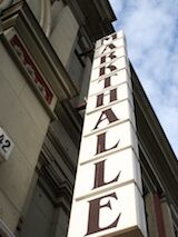 Auf dem Foto ist die Leuchtmittel-Reklame an der Außenwand der Markthalle Neun zu sehen.